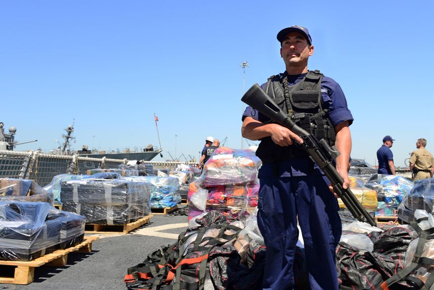 In this photo provided by the U.S. Coast Guard, a crewman from the Coast Guard Cutter Boutwell guards some of more than 28,000 pounds of cocaine, seized at sea and offloaded at Naval Base San Diego, Thursday, April 16, 2015. The vessel arrived with more than 14 tons of cocaine, part of what authorities described as a surge of seizures near Central and South America. (U.S. Coast Guard photo by Petty Officer 2nd Class Connie Terrell via AP)