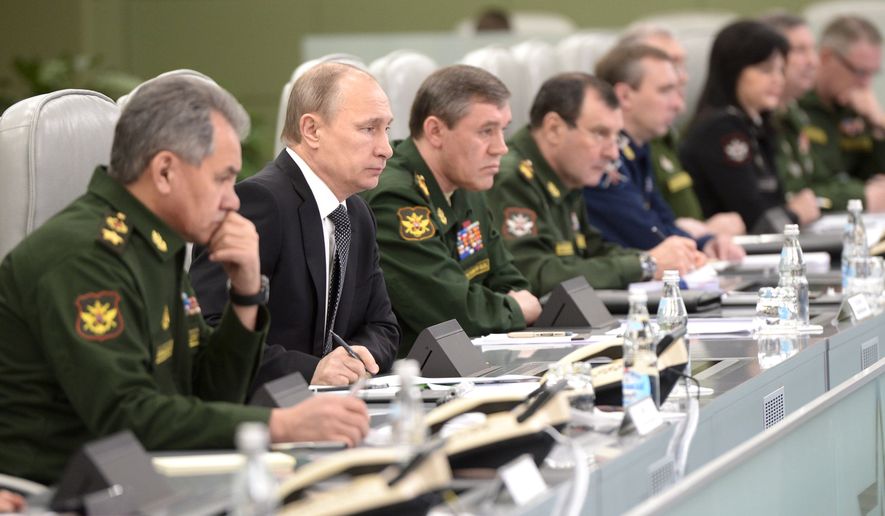 Russian President Vladimir Putin, second left, flanked by Defense Minister Sergei Shoigu, left, and Chief of the General Staff of the Russian Armed Forces Valery Gerasimov, third left, visits the National Defense Control Center in Moscow, Russia, Friday, April 17, 2015. (Alexei Nikolsky/ RIA-Novosti, Kremlin Pool Photo via AP)
