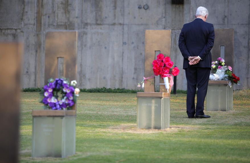 Former President Bill Clinton stands in the Field of Empty Chairs at the chair of Oklahoma City bombing victim Alan G. Whicher,of the U.S. Secret Service, after lying a bouquet of flowers on the chair during a visit to the Oklahoma City National Memorial in Oklahoma City. (AP Photo/Bryan Terry, Pool)