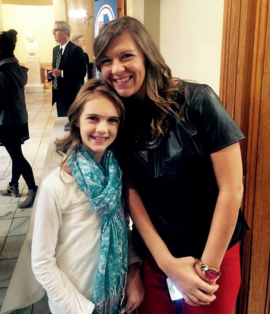 In this Jan. 28, 2015 photo, Anna Bullard poses for a photo with her daughter Ava on Autism Day at the state Capitol in Atlanta. Each day as Georgia Gov. Nathan Deal plods through a stack of more than 300 bills passed by the 2015 General Assembly, Anna Bullard becomes just a tad more anxious. When, she wonders, will he sign Senate Bill 1, turning what’s now just another piece of legislation into Ava’s Law - named after her little girl, and making Georgia the 41st state to require private insurance companies to cover therapy for children with autism? April is Autism Awareness Month, so he’s expected to sign it before May 1. Deal has until May 12 to sign or veto bills. (Judith Ursitti/Anna Bullard via AP)