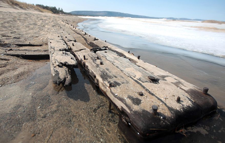FILE-In this photo taken on April 6, 2014, the tip of a 40-foot-long section of a shipwreck juts out sand along Lake Michigan north of Glen Arbor, Mich., near the Crystal River. Changing water levels, erosion and water conditions cause shipwrecks in northern Lake Michigan do periodically disappear and re-appear. A U.S. Coast Guard crew from Traverse City, Mich., spotted and photographed several shipwrecks in the area on Friday, April 17, 2015. (Nathan Payne/The Record-Eagle via AP)