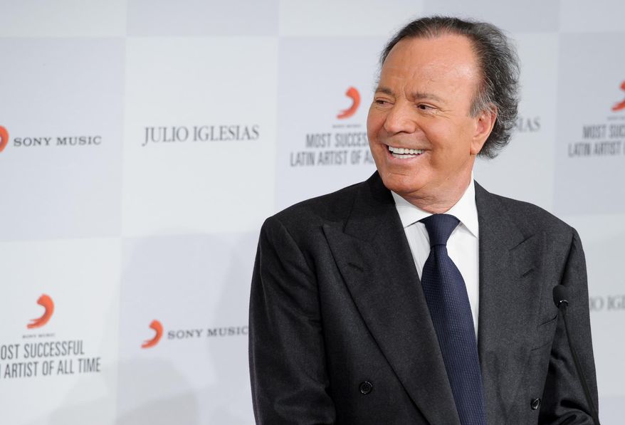 FILE - In this May 12, 2014 file photo, Latin pop icon Julio Iglesias poses for photographers at a news conference where he was named the 'Most Successful Latin Artist of All Time', at a central London venue. Iglesias and three other prominent music industry figures will receive honorary degrees from Boston's Berklee College of Music at its commencement next month. (Photo by Jonathan Short/Invision/AP, File)
