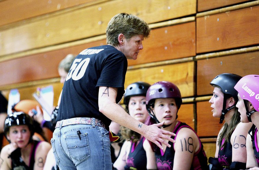 In this March 12, 2015 photo, Barbed Wire Betties Bench Coach Lee Clark talks to her team on the bench during a bout against the Illinois Valley Vixens at Huntley Middle School in DeKalb, Ill. Clark has recently returned from an eight-month stint in Antarctica as a 911 dispatcher. (Monica Synett/Daily Chronicle via AP) CHICAGO TRIBUNE OUT, MANDATORY CREDIT