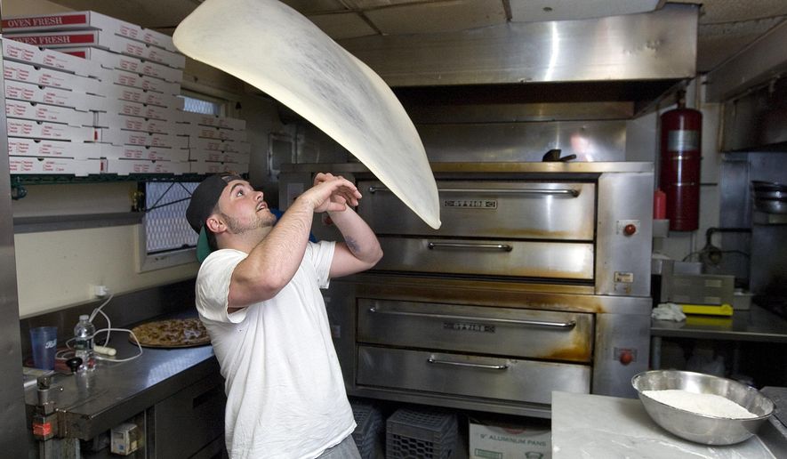 ADVANCE FOR WEEKEND OF APRIL 18, 2015, AND THEREAFTER- In this April 7, 2015, photo, Ace Memeti, manager of Formaggio Apizza Ristorante, twirls pizza dough in Southington, Conn. The restaurant placed third in a national pizza dough stretching competition in Las Vegas. (Dave Zajac/The Record-Journal via AP)