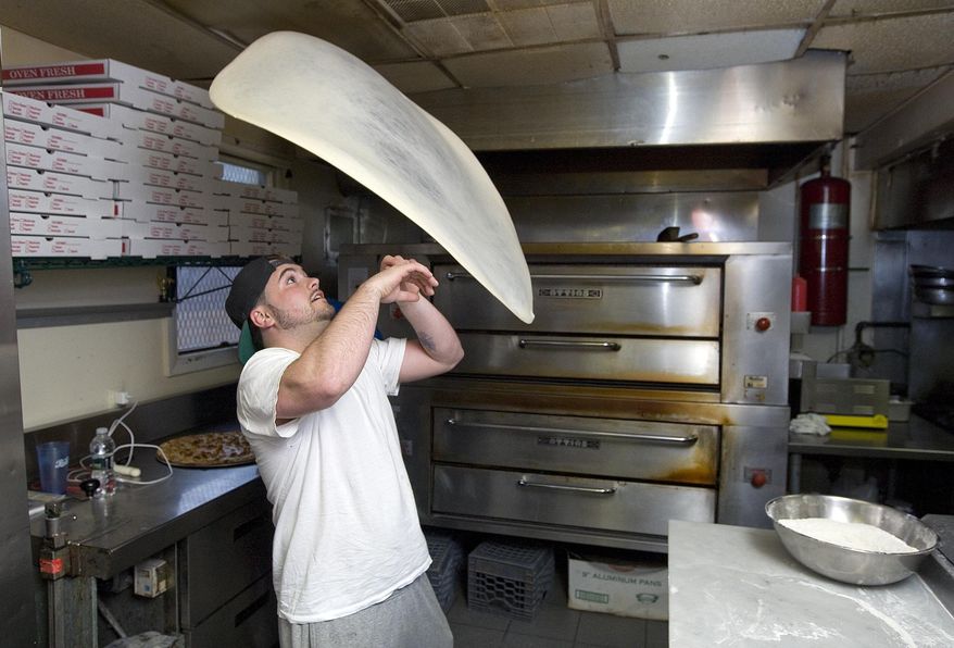 ADVANCE FOR WEEKEND OF APRIL 18, 2015, AND THEREAFTER- In this April 7, 2015, photo, Ace Memeti, manager of Formaggio Apizza Ristorante, twirls pizza dough in Southington, Conn. The restaurant placed third in a national pizza dough stretching competition in Las Vegas. (Dave Zajac/The Record-Journal via AP)