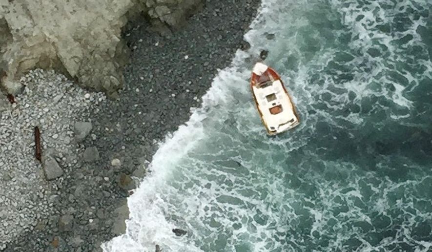 This April 18, 2015 aerial photo from the Sonoma County, Calif., Sheriff's Office shows a 21-foot boat overturned in the rocks near Tomales Point in Marin County, Calif. Authorities say two people have been found dead and two others remain missing following the boating accident off the Northern California coast. The Sonoma County Sheriff's office says the search for the fishing party was launched Friday evening after someone reported that the boaters had not returned to dock near Bodega Bay. A Coast Guard crew spotted the boat Saturday morning. (Sonoma County Sheriff's Office via AP)