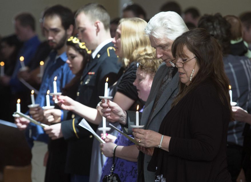Geraldine Schultz's family members sing "Amazing Grace" and light candles at the conclusion of her funeral Saturday, April 18, 2015, at Westminster Presbyterian Church in Rockford, Ill. Schultz was killed in a tornado April 9. (Sunny Strader/Rockford Register Star via AP)