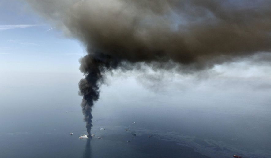 FILE - In this April 21, 2010 file photo by Gerald Herbert, the Deepwater Horizon oil rig burns in the Gulf of Mexico. Rig fires happen with some regularity, but when word came that the rig was listing badly after an explosion the night before, New Orleans-based Herbert raced to a small airport and grabbed the first helicopter pilot he could find. Together with a photographer from the Times-Picayune newspaper, the three headed out in a four-seat helicopter with only enough fuel to get to the site and shoot for a few minutes. "You could see it for miles," Herbert recalled. The smoke "started appearing through the haze as a thick blob,” he said. "As we got closer, we realized how immense it was. The smoke was actually higher than us, and we were circling around it trying to avoid it." Hovering at 4,000 feet _ the lowest authorities would allow them to fly _ the three were struck by the scale of the unfolding disaster. "The enormity of it did not escape us, because you could see that what looked like a tiny little burning ember was a massive oil platform. You could see oil in the water," Herbert said. The images were the first from what would become the nation’s worst offshore spill. The rig would sink within three days of exploding, and the oil would flow unchecked for nearly three months. (AP Photo/Gerald Herbert, File)