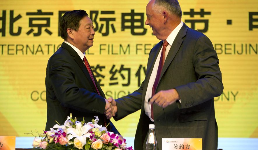 Li Shilin, left, head of China's CITIC Guoan, a unit of state-owned CITIC Group Corporation, and Dick Cook, former Walt Disney Studios Chairman and current head of Dick Cook Studios, shake hands after signing an agreement during a contract signing event held as part of the Beijing International Film Festival in Beijing, Monday, April 20, 2015. Walt Disney Studios signed a deal with CITIC Guoan to invest $150 million into his new Dick Cook Studios. (AP Photo/Mark Schiefelbein)
