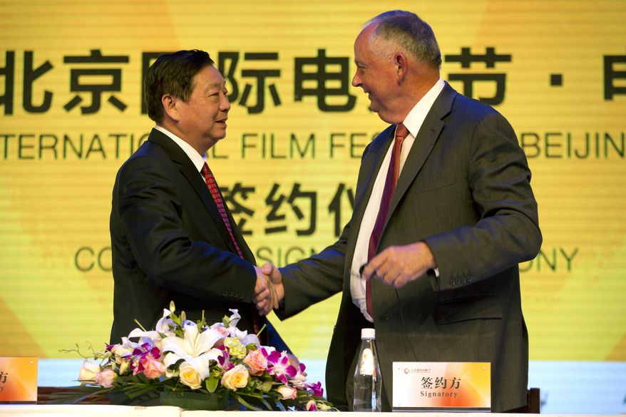 Li Shilin, left, head of China's CITIC Guoan, a unit of state-owned CITIC Group Corporation, and Dick Cook, former Walt Disney Studios Chairman and current head of Dick Cook Studios, shake hands after signing an agreement during a contract signing event held as part of the Beijing International Film Festival in Beijing, Monday, April 20, 2015. Walt Disney Studios signed a deal with CITIC Guoan to invest $150 million into his new Dick Cook Studios. (AP Photo/Mark Schiefelbein)