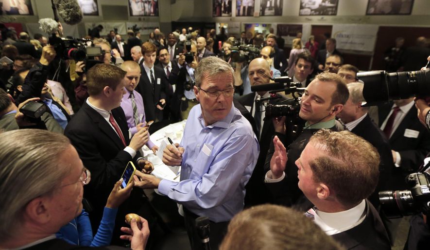 Former Florida Gov. Jeb Bush, center, mingles at a "Politics and Eggs" event, a breakfast fixture for 2016 presidential prospects, Friday, April 17, 2015, at Saint Anselm College in Manchester, N.H. (AP Photo/Elise Amendola)