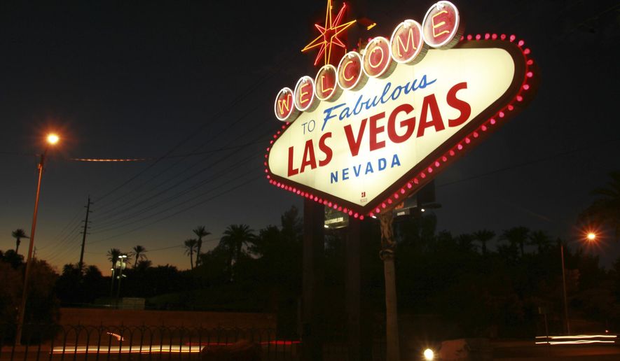 File - In this Oct. 4, 2012, file photo, the "Welcome to Fabulous Las Vegas" neon sign is outlined in pink lightbulbs in honor of breast cancer awareness month in Las Vegas. Betty Willis, the woman who designed the iconic neon sign that has welcomed countless visitors to Las Vegas since 1959 has died. She was 91. (Sam Morris/Las Vegas Sun via AP, File)