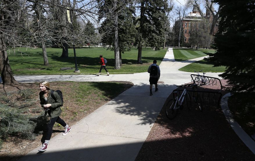 Students walk to and from classes on the campus quad of the University of Colorado, in Boulder, Colo., Monday April 20, 2015. The University of Colorado is open to the public on this 4/20 marijuana holiday for the first time in three years. The university has blocked public access in recent years in an effort to snuff mass smokeouts to mark the unofficial marijuana celebration. (AP Photo/Brennan Linsley)