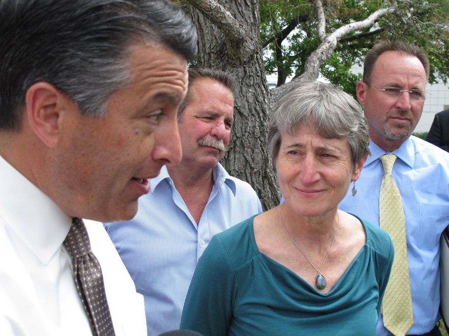 U.S. Interior Secretary Sally Jewell, right, looks on as Nevada Gov. Brian Sandoval, left, answers questions from reporters in Reno, Nev., Tuesday, April 21, 2015 after she announced her reversal of proposed federal protection of the bistate sage grouse along the California-Nevada line. Jewell says withdrawal of a proposal to declare the bird unique to Nevada and California as threatened should be encouraging for those trying to head off a bigger listing decision looming for greater sage grouse in 11 western states. (AP Photo/Scott Sonner)