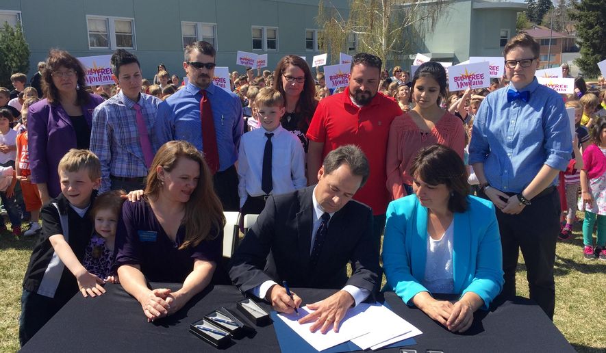 Montana Gov. Steve Bullock signs the Bully Free Montana Act Tuesday, April 21, 2015 at Jefferson Elementary in Helena, Mont., while bill sponsor Rep. Kim Dudik, left, and Superintendent of Public Instruction Denise Juneau look on. Lawmakers have been trying to pass some form of the measure since 2003 with opponents saying it would infringe on school districts' ability to enact local rules. Forty-six of the 49 states that have established bullying laws did so by 2010. (AP Photo/Lisa Baumann)