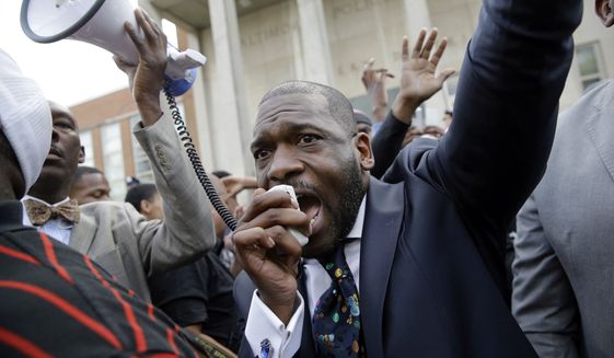 Rev. Jamal Bryant leads a rally outside of the Baltimore Police Department&#39;s Western District station during a march and vigil for Freddie Gray on Tuesday in Baltimore. Mr. Gray died from spinal injuries a week after he was arrested and transported in a police van. (Associated Press)