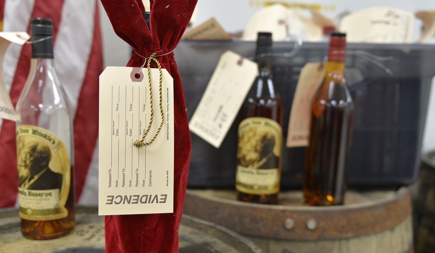 Evidence tags mark recovered bottles of Pappy Van Winkle bourbon shown during a news conference at the Franklin County Sheriff's Office, Tuesday, April 21, 2015, in Frankfort, Ky. Nine people were indicted relating to the theft of more than $100,000 worth of bourbon from the Wild Turkey and Buffalo Trace distilleries. (AP Photo/Timothy D. Easley)
