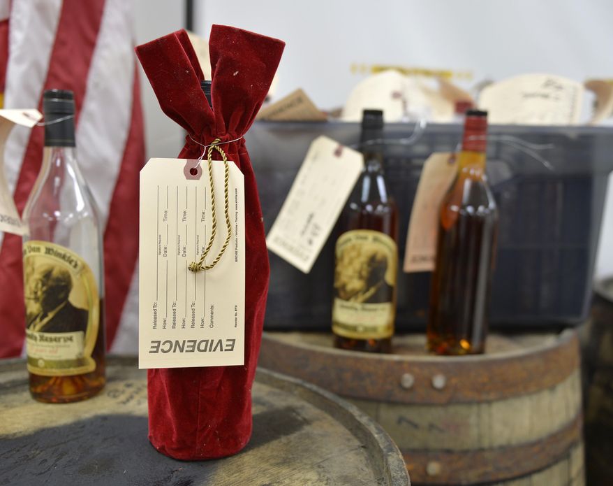 Evidence tags mark recovered bottles of Pappy Van Winkle bourbon shown during a news conference at the Franklin County Sheriff's Office, Tuesday, April 21, 2015, in Frankfort, Ky. Nine people were indicted relating to the theft of more than $100,000 worth of bourbon from the Wild Turkey and Buffalo Trace distilleries. (AP Photo/Timothy D. Easley)