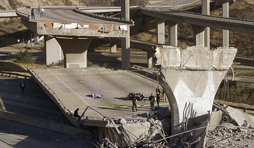 FILE - In this Jan. 17, 1994 file photo, the covered body of Los Angeles Police Officer Clarence Wayne Dean, 46, lies near his motorcycle which plunged off the State Highway 14 overpass that collapsed onto Interstate 5, after a magnitude-6.7 Northridge earthquake. The U.S. Geological Survey said more than 143 million people in the continental U.S. live in an earthquake zone and are exposed to potentially damaging ground shaking. (AP Photo/Doug Pizac, File)