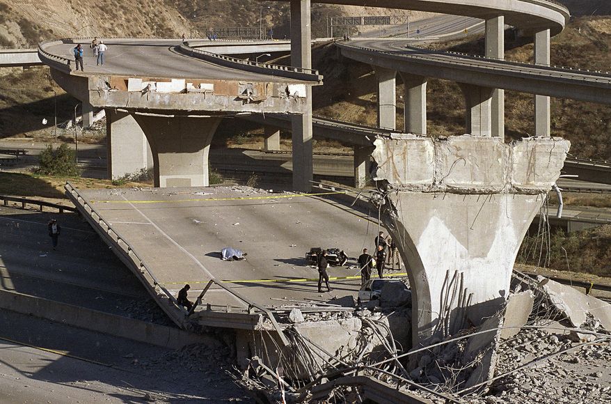 FILE - In this Jan. 17, 1994 file photo, the covered body of Los Angeles Police Officer Clarence Wayne Dean, 46, lies near his motorcycle which plunged off the State Highway 14 overpass that collapsed onto Interstate 5, after a magnitude-6.7 Northridge earthquake. The U.S. Geological Survey said more than 143 million people in the continental U.S. live in an earthquake zone and are exposed to potentially damaging ground shaking. (AP Photo/Doug Pizac, File)