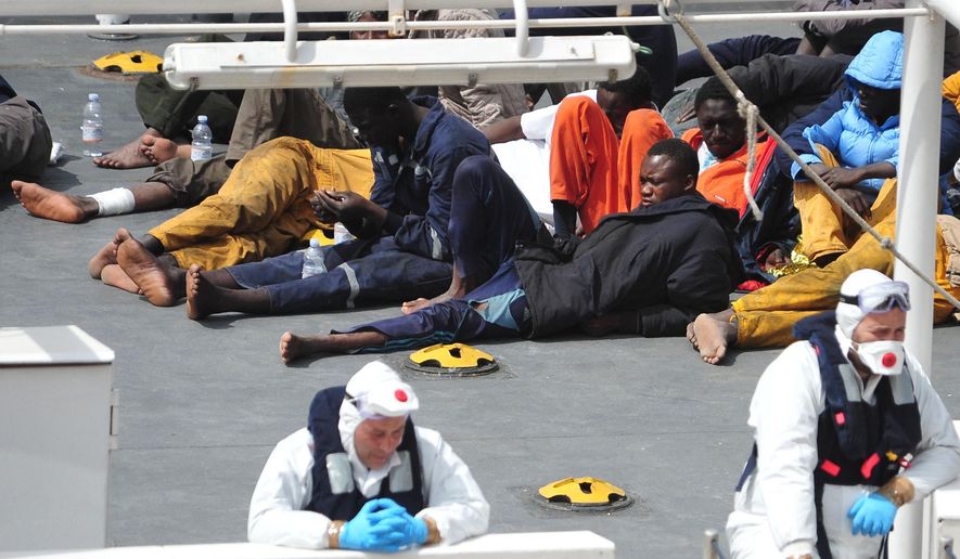 In this Monday, April 20, 2015, file photo, survivors of the smuggler's boat that overturned off the coast of Libya rest on the deck of the Italian Coast Guard ship Bruno Gregoretti, in Valletta's Grand Harbour. The United Nations refugee agency said Tuesday that more than 800 people were believed to have drowned in the weekend sinking of a boat packed with migrants trying to reach Europe, making it the deadliest such disaster in the Mediterranean. (AP Photo/Lino Azzopardi, File)