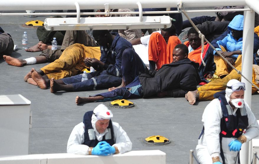 In this Monday, April 20, 2015, file photo, survivors of the smuggler's boat that overturned off the coast of Libya rest on the deck of the Italian Coast Guard ship Bruno Gregoretti, in Valletta's Grand Harbour. The United Nations refugee agency said Tuesday that more than 800 people were believed to have drowned in the weekend sinking of a boat packed with migrants trying to reach Europe, making it the deadliest such disaster in the Mediterranean. (AP Photo/Lino Azzopardi, File)