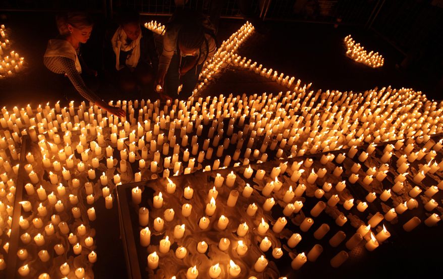 Hundreds of candles are lit during a silent vigil outside the Constitutional Court in Johannesburg, Tuesday, April 21, 2015. The vigil was held in an effort to take a stand against the ongoing immigrant attacks in South Africa as the army has been deployed to areas that remain volatile after a spate of attacks targeting foreign nationals. (AP Photo/Denis Farrell)