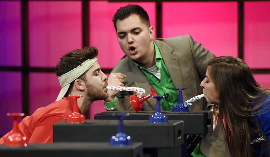 In this Tuesday, March 31, 2015 photo, host Elliot Morgan, center, watches over contestants Dominic DeAngelis, left, and Gabie Hanna as they try to knock over glasses with party whistles during a taping of the classic game show "Beat the Clock," at YouTube Space LA, in Los Angeles. FremantleMedia, the company that owns the rights to "Beat the Clock" and more than 150 other game show formats, commissioned original digital content studio Tiny Riot! to produce content for Buzzr. (Photo by Chris Pizzello/Invision/AP)