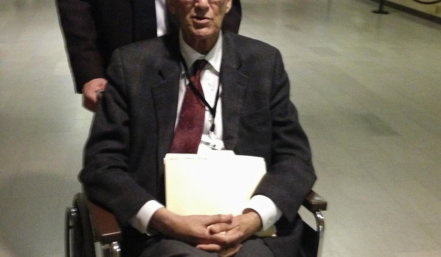Democratic Rep. Eliot Glassheim of Grand Forks is wheeled throughout the halls of the Capitol in Bismarck, N.D., Wednesday, April 22, 2015, by fellow Grand Forks Democratic Rep. Corey Mock as he returned to the state Legislature after missing two days of the session with what was believed to be a mild stroke. Glassheim got a rousing reception in the House and joked about getting sick again to get such a response. (AP Photo/Dave Kolpack)