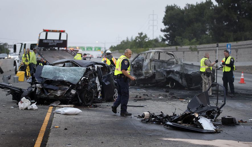 Officials investigate the accident on U.S. Route 50 where authorities say four people were killed in a wrong-way crash that blocked several lanes of a freeway early Wednesday, April 22, 2015, in Sacramento, Calif. The collision resulted in the death of the wrong-way driver, a woman in the Toyota Prius, shown here, and three men in a Ford pickup. A third vehicle was involved, but the driver suffered only minor injuries. (Randy Pench/The Sacramento Bee via AP) MAGS OUT; LOCAL TELEVISION OUT MANDATORY CREDIT