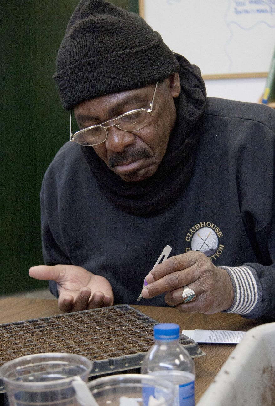 ADVANCE FOR USE SUNDAY, APRIL 26 AND THEREAFTER - In this March 24, 2015 photo, Patrick Slater places seeds into the germination mix at Mercy Gardens in Decatur, Ill. The new Mercy Gardens job training began earlier in the month at the Good Samaritan Inn. (Hugh Sullivan/Herald & Review via AP)