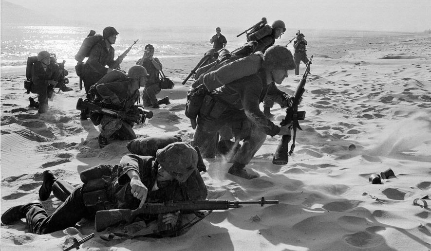 Newly-landed U.S. Marines make their way through the sands of Red Beach at Da Nang, Vietnam on their way to reinforce the air base as South Vietnamese Rangers battled guerrillas about three miles south of the beach. (AP Photo/Peter Arnett, File)