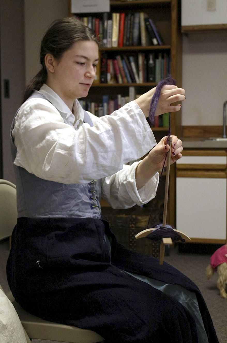 In this April 18, 2015 photo, Hanna Clary spins wool into yarn using a drop spindle during “Hands on the Past,” a day of learning about medieval arts and science, by the local Society for Creative Anachronism group in Kodiak, Alaska. Most people don’t think about where their clothes come from, but members of the Society for Creative Anachronism, who re-enact medieval lifestyles, know it takes a lot of work to get from raw fibers to clothing. (Julie Herrmann/Kodiak Daily Mirror via AP)