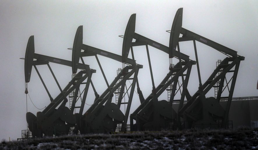 FILE - In this Dec. 19, 2014 file photo, oil pump jacks work in unison, in Williston, N.D. In the year since the energy industry last gathered in for its big annual confab in Houston, prices for oil and natural gas took a dive that few, if anyone, saw coming. In 2015, natural gas has fallen even further than oil as U.S. drillers have been producing enormous amounts of gas and mild winter weather kept demand relatively low. (AP Photo/Eric Gay, File)