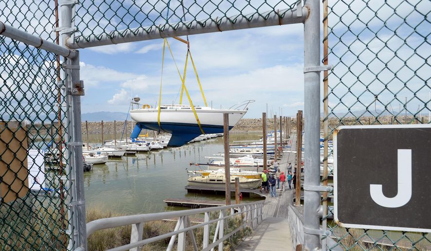 A crane lifts a sailboat from its slip at the Great Salt Lake State Marina in Tooele, Utah, Thursday, April 23, 2015. The two-day removal of 80 sailboats began Thursday in preparation for a sediment removal project later this year. The lake's waters are reaching historic lows and without dredging, boats risk damage from keels becoming wedged in the mud. (Steve Griffin/The Salt Lake Tribune via AP)