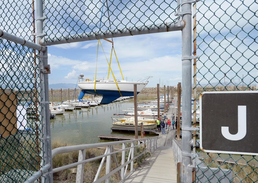 A crane lifts a sailboat from its slip at the Great Salt Lake State Marina in Tooele, Utah, Thursday, April 23, 2015. The two-day removal of 80 sailboats began Thursday in preparation for a sediment removal project later this year. The lake's waters are reaching historic lows and without dredging, boats risk damage from keels becoming wedged in the mud. (Steve Griffin/The Salt Lake Tribune via AP)
