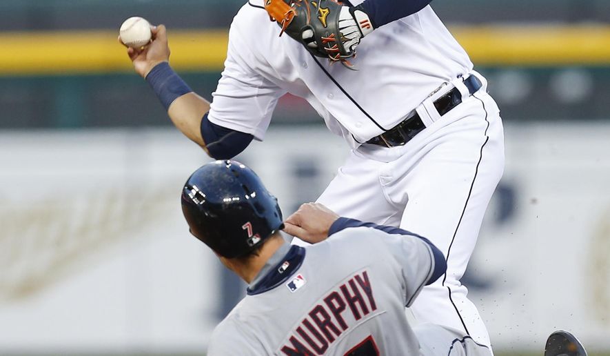 Detroit Tigers shortstop Jose Iglesias, top, throws to first base as Cleveland Indians&#39; David Murphy (7) slides to complete a double play on a Roberto Perez ground ball in the fourth inning of a baseball game in Detroit, Friday, April 24, 2015. (AP Photo/Paul Sancya)