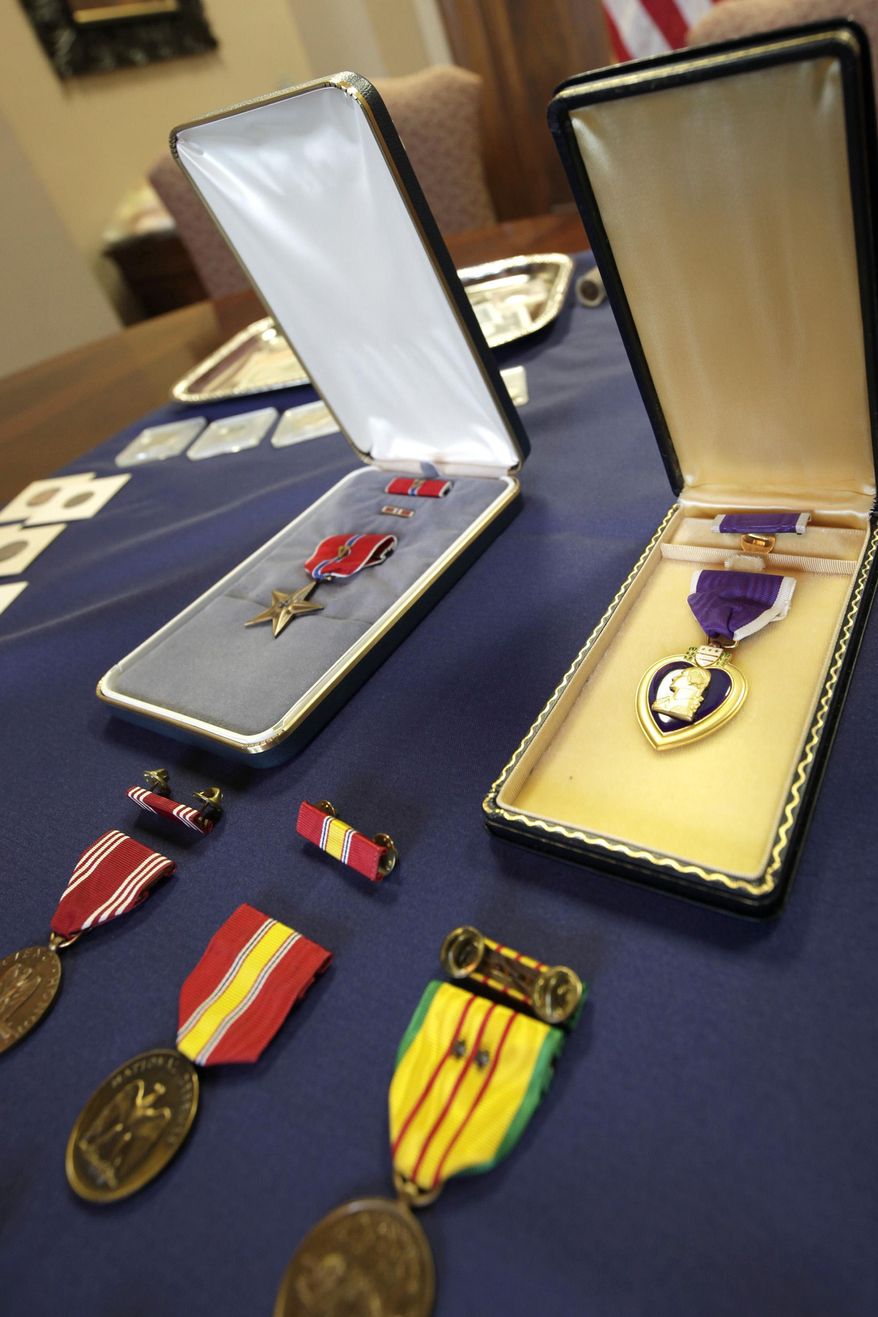 A Bronze Star, top left, Purple Heart, right, and other medals are displayed at the Auditor of State&#39;s office in Little Rock, Ark., Friday, April 24, 2015. (AP Photo/Danny Johnston) ** FILE **