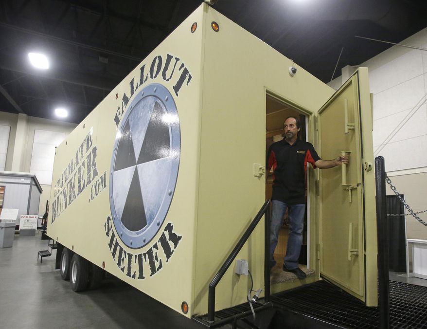 Mike Peters, with Ultimate Bunker stands at the doorway of a 100% steel underground bunker during the PrepperCon expo Friday, April 24, 2015, in Sandy, Utah. Hundreds of survivalists and "preppers" are gathering in the Salt Lake City suburb of Sandy for the first annual PrepperCon, featuring demonstrations of underground bunkers, food storage, and armored vehicles. (AP Photo/Rick Bowmer)