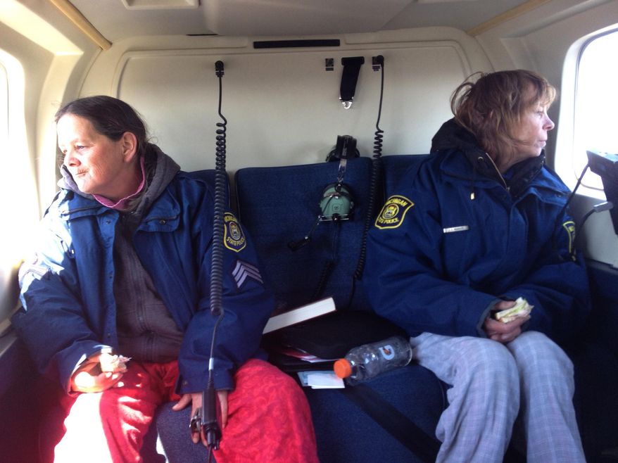 Sisters Leslie Roy, right, and Lee Marie Wright sit in a Michigan State Police helicopter after they were rescued Friday, April 24, 2015 from Michigan's Upper Penisula. The sisters survived 13 days in a remote part of the Upper Penisula after their SUV got stuck about 3 miles from Lake Superior. The area has no cellphone service. They were rescued Friday by a police helicopter pilot who noticed a reflection off their SUV. The sisters say they survived on love for their family, melted snow and the Girl Scout cookies and cheese puffs they had in their snow-crippled SUV. (Michigan Department of State Police via AP)