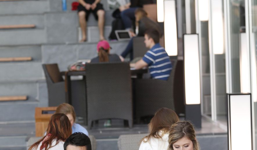 Liberty University students work in the atrium of the Jerry Falwell library at the school in Lynchburg, Va., Tuesday, April 21, 2015. Amid a $500 million construction boom, Liberty University is more construction zone than campus. Located in the foothills of Virginia’s Blue Ridge mountains, Liberty now claims more than 100,000 students, with most of that number reflecting distance learners. (AP Photo/Steve Helber)