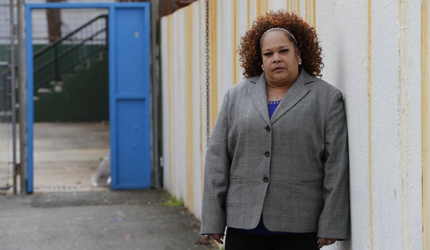 In this Thursday, April 23, 2015, photo Shalga Hightower, mother of Iofemi Hightower, college student slain in 2007, poses for The Associated Press in the schoolyard where the murder happened in Newark, N.J. In the seven-plus years since her college-bound daughter's brutal slaying along with two friends in a case that became a national symbol of urban gun violence, Hightower has been on a mission. It started with a resolve to attend every court hearing involving the six men and boys eventually convicted for the crime, an odyssey that cost her her job and left her family temporarily homeless. Now, a documentary project is aiming to chronicle her struggles and her efforts on behalf of families of crime victims who are too often left to fend for themselves. (AP Photo/Julio Cortez)