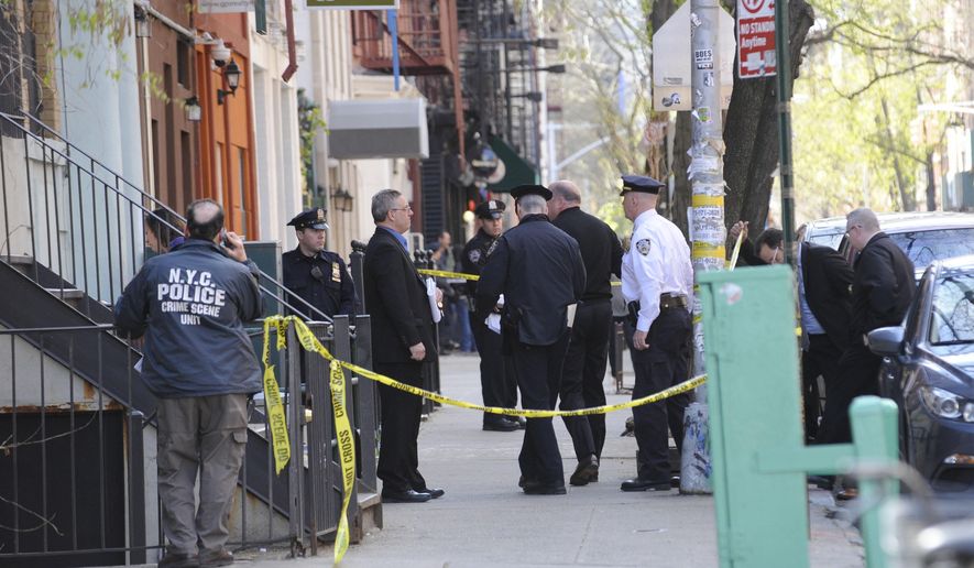 Police personnel gather at the scene of a police shooting on 6th street in the East Village, Saturday, April, 2015, in New York. (AP Photo/ Louis Lanzano)