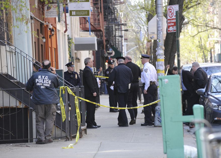 Police personnel gather at the scene of a police shooting on 6th street in the East Village, Saturday, April, 2015, in New York. (AP Photo/ Louis Lanzano)