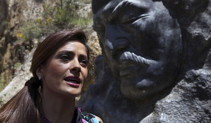 Mexican and American actress Salma Hayek sits in front of the statue of Lebanese-American poet Khalil Gibran during her visit to his museum in the northeast mountain town of Bcharre, Lebanon, Sunday, April 26, 2015. Hayek visited her ancestral homeland Lebanon to launch her latest film "The Prophet," a screen adaptation of the book by the same name written nearly a century ago by the famed Lebanese-American poet and philosopher Gibran. (AP Photo/Bilal Hussein)