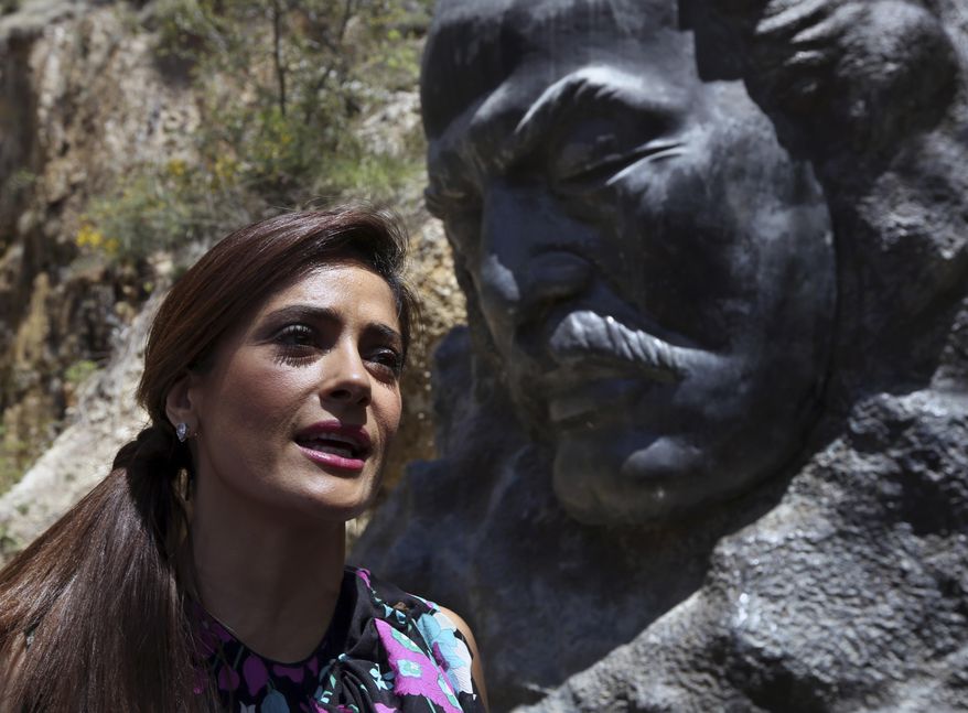 Mexican and American actress Salma Hayek sits in front of the statue of Lebanese-American poet Khalil Gibran during her visit to his museum in the northeast mountain town of Bcharre, Lebanon, Sunday, April 26, 2015. Hayek visited her ancestral homeland Lebanon to launch her latest film "The Prophet," a screen adaptation of the book by the same name written nearly a century ago by the famed Lebanese-American poet and philosopher Gibran. (AP Photo/Bilal Hussein)