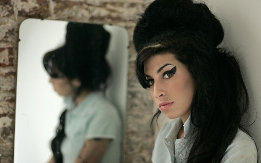 FILE - In this Feb. 16, 2007 file photo, British singer Amy Winehouse poses for photographs after being interviewed by The Associated Press at a studio in north London. The family of Amy Winehouse has criticized a documentary about the late singer that is due to have its premiere at next month's Cannes Film Festival.A statement issued Sunday, April 26, 2015 by family spokesman Chris Goodman said director Asif Kapadia's "Amy" is "misleading and contains some basic untruths." The statement said the film suggested family members did too little to help the singer, who died in July 2011, aged 27, after battling drug and alcohol abuse. (AP Photo/Matt Dunham, File)