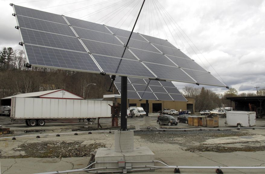 In this Thursday, April 23, 2015 photo, some of the solar trackers that provide power for the town of Norwich, Vt., face skyward in White River Junction, Vt. Norwich is the first community in the state where all municipal buildings get their electricity from the sun. Town officials said they want to do their part to help the state reach it's long-term goal of having 90 percent of the state's energy come from renewable sources by 2050. (AP Photo/Wilson Ring)