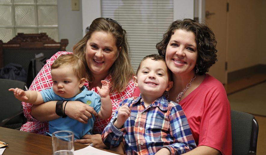 Pam Yorksmith, left, and her spouse Nicole Yorksmith, along with their children, Grayden, 4, and Orion, are photographed in the office of their attorney, Gerhardstein & Branch Co. LPA, Friday, April 3, 2015 in Cincinnati. A middle-of-the night trip to the emergency room, with her 9-month-old son coughing and laboring to breathe, gave Pam Yorksmith her latest reminder of why she took up the fight for same-sex marriage. Before baby Orion could be treated for croup, the hospital had to call his birth mother, Yorksmith’s wife, Nicole, "to get permission to treat my child," Yorksmith said. The are among the 19 men and 12 women whose same-sex marriage cases from those two states, plus Michigan and Tennessee, will be argued at the Supreme Court on April 28. (AP Photo/Gary Landers)