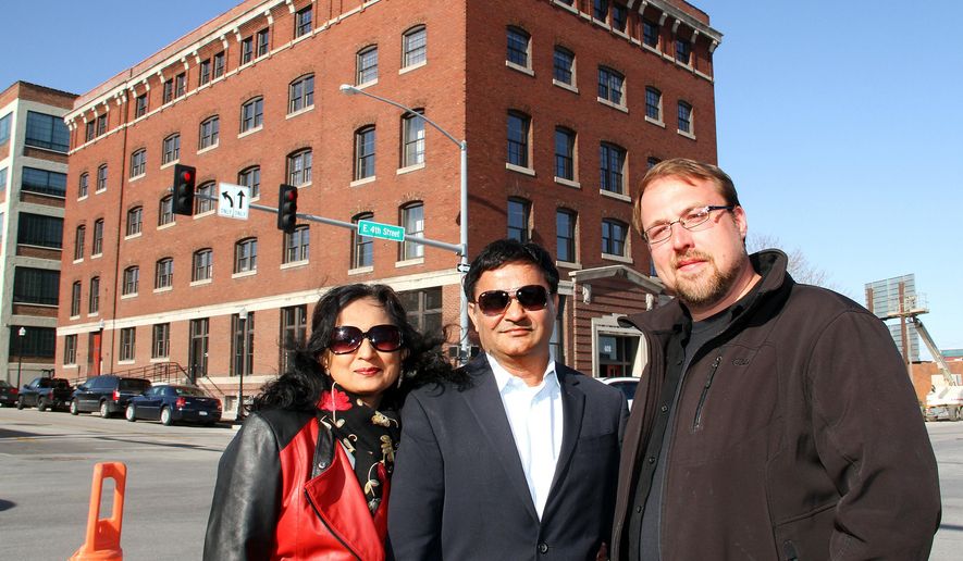 ADVANCE FOR WEEKEND EDITIONS APRIL 25-26 - In this April 22, 2015 photo, Manisha, left and Manoj Baheti, owners of Y & J Properties, with developer Joe Erenberger developed the Halligan Coffee Company Lofts into 45 market rate lofts that will be available for occupancy on May 1 in Davenport, Iowa. Y & J Properties celebrated the completion of its most recent project, the $6.5 million Halligan Coffee Co. Lofts. Business leaders, city officials and others attended a ribbon-cutting ceremony Wednesday, April 22, 2015. (Kevin E. Schmidt/The Quad City Times via AP) MANDATORY CREDIT